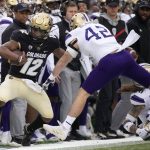 Washington linebacker Carson Bruener, right, and teammates push Colorado quarterback Brendon Lewis out of bounds after a long gain during the first half of an NCAA college football game Saturday, Nov. 20, 2021, in Boulder, Colo. (AP Photo/David Zalubowski)