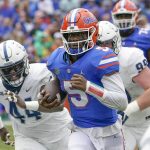 
              Florida quarterback Emory Jones (5) scores a touchdown on a 31-yard run as he gets past Samford defender Tay Berry, left, and defensive tackle Seth Simmerduring the first half of an NCAA college football game, Saturday, Nov. 13, 2021, in Gainesville, Fla. (AP Photo/John Raoux)
            