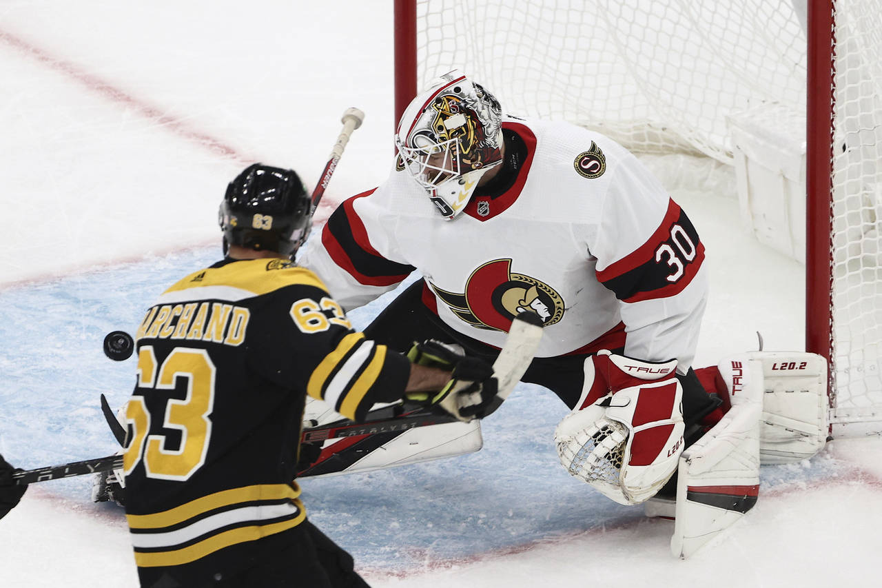 Ottawa Senators goaltender Matt Murray makes a save as Boston Bruins' Brad Marchand looks for the r...