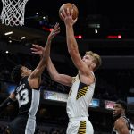 
              Indiana Pacers forward Domantas Sabonis (11) shoots over San Antonio Spurs guard Tre Jones (33) during the second half of an NBA basketball game in Indianapolis, Monday, Nov. 1, 2021. The Pacers defeated the Spurs 131-118. (AP Photo/Michael Conroy)
            