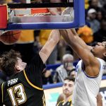 
              Pittsburgh's Noah Collier, right, dunks as Towson's Chase Paar (13) defends during the second half of an NCAA college basketball game Friday, Nov. 19, 2021, in Pittsburgh. Pittsburgh won 63-59. (AP Photo/Keith Srakocic)
            