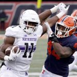 
              Northwestern running back Andrew Clair (11) tries to stiff arm Illinois linebacker Tarique Barnes during the first half of an NCAA college football game Saturday, Nov. 27, 2021, in Champaign, Ill. (AP Photo/Charles Rex Arbogast)
            