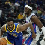 
              Golden State Warriors forward Andrew Wiggins (22) drives around Detroit Pistons forward Jerami Grant during the first half of an NBA basketball game, Friday, Nov. 19, 2021, in Detroit. (AP Photo/Carlos Osorio)
            