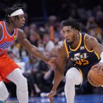 
              Utah Jazz guard Donovan Mitchell (45) is defended by Oklahoma City Thunder forward Luguentz Dort during the second half of an NBA basketball game Wednesday, Nov. 24, 2021, in Oklahoma City. (AP Photo/Sue Ogrocki)
            