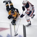 
              Boston Bruins defenseman Brandon Carlo, left, dives as he tries to strip the puck away from Edmonton Oilers center Connor McDavid (97) during the first period of an NHL hockey game, Thursday, Nov. 11, 2021, in Boston. (AP Photo/Charles Krupa)
            