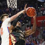 
              Florida forward Colin Castleton, left, blocks a shot attempt by Florida State forward Malik Osborne (10) during the first half of an NCAA college basketball game, Sunday, Nov. 14, 2021, in Gainesville, Fla. (AP Photo/John Raoux)
            