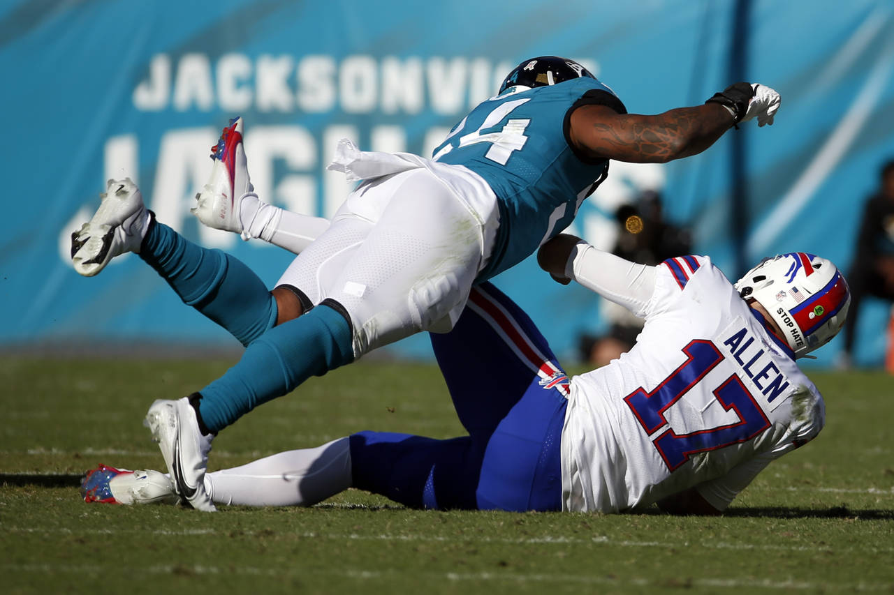Jacksonville Jaguars linebacker Damien Wilson, left, tackles Buffalo Bills quarterback Josh Allen (...