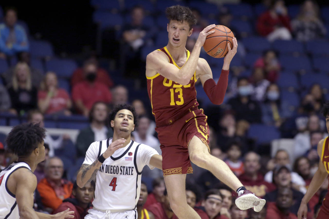 Southern California guard Drew Peterson, right, pulls down a loose ball in front of San Diego State...