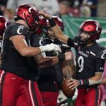 
              Cincinnati quarterback Desmond Ridder (9) celebrates with teammates after his 13-yard touchdown run against South Florida during the first half of an NCAA college football game Friday, Nov. 12, 2021, in Tampa, Fla. (AP Photo/Chris O'Meara)
            