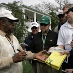 
              FILE - Lee Elder signs autographs for patrons outside the club house at the 2008 Masters golf tournament at the Augusta National Golf Club in Augusta, Ga., Monday, April 7, 2008. Elder broke down racial barriers as the first Black golfer to play in the Masters and paved the way for Tiger Woods and others to follow. The PGA Tour confirmed Elder’s death, which was first reported by Debert Cook of African American Golfers Digest. No cause or details were immediately available, but the tour said it spoke with Elder's family. He was 87.  (AP Photo/Elise Amendola, File)
            