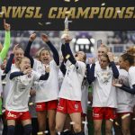 
              Washington Spirit's Andi Sullivan, center, lifts the trophy as they celebrate after defeating the Chicago Red Stars in the NWSL Championship soccer match, Saturday, Nov. 20, 2021, in Louisville, Ky. (AP Photo/Jeff Dean)
            