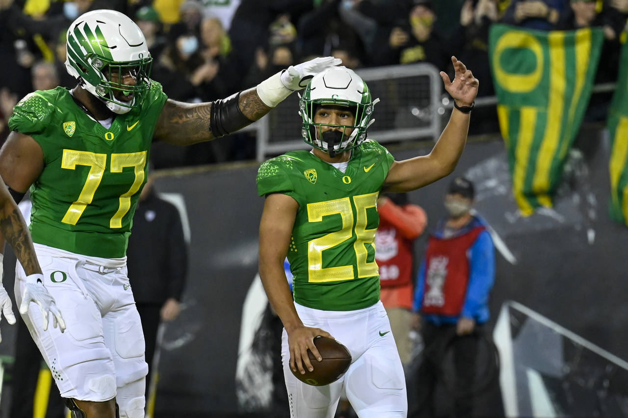 Oregon running back Travis Dye (26) celebrates his touchdown against Washington St with offensive l...