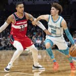 
              Washington Wizards forward Kyle Kuzma (33) guards Charlotte Hornets guard LaMelo Ball (2) during the first half of an NBA basketball game in Charlotte, N.C., Wednesday, Nov. 17, 2021. (AP Photo/Jacob Kupferman)
            
