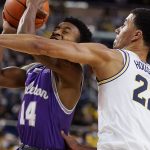
              Tarleton State guard Javontae Hopkins (14) is defended by Michigan forward Caleb Houstan (22) during the first half of an NCAA college basketball game, Wednesday, Nov. 24, 2021, in Ann Arbor, Mich. (AP Photo/Carlos Osorio)
            