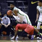 
              Oregon forward Quincy Guerrier (13) looks to pass after getting possession of a loose ball against SMU guard Kendric Davis (3) during the first half of an NCAA college basketball game Friday, Nov. 12, 2021, in Eugene, Ore. (AP Photo/Andy Nelson)
            