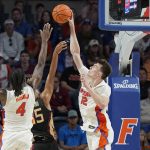 
              Florida forward Colin Castleton (12) blocks a shot by Florida State guard Matthew Cleveland, center, as Florida forward Anthony Duruji (4) moves in to help during the second half of an NCAA college basketball game, Sunday, Nov. 14, 2021, in Gainesville, Fla. (AP Photo/John Raoux)
            