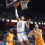 
              North Carolina's Dawson Garcia (13) makes a basket as Tennessee's Brandon Huntley-Hatfield (2) and Tennessee's Uros Plavsic (33) look on, in the first half of an NCAA college basketball game, Sunday, Nov. 21, 2021, in Uncasville, Conn. (AP Photo/Jessica Hill)
            
