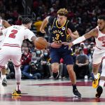
              Indiana Pacers guard Chris Duarte, center, chases the ball as Chicago Bulls guard Lonzo Ball, left, and forward Troy Brown Jr. defend during the first half of an NBA basketball game in Chicago, Monday, Nov. 22, 2021. (AP Photo/Nam Y. Huh)
            