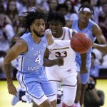 
              North Carolina's RJ Davis (4) brings the ball up as College of Charleston's Osinachi Smart (33) trails during the first half of an NCAA college basketball game Tuesday, Nov. 16, 2021, in Charleston, S.C. (AP Photo/Mic Smith)
            