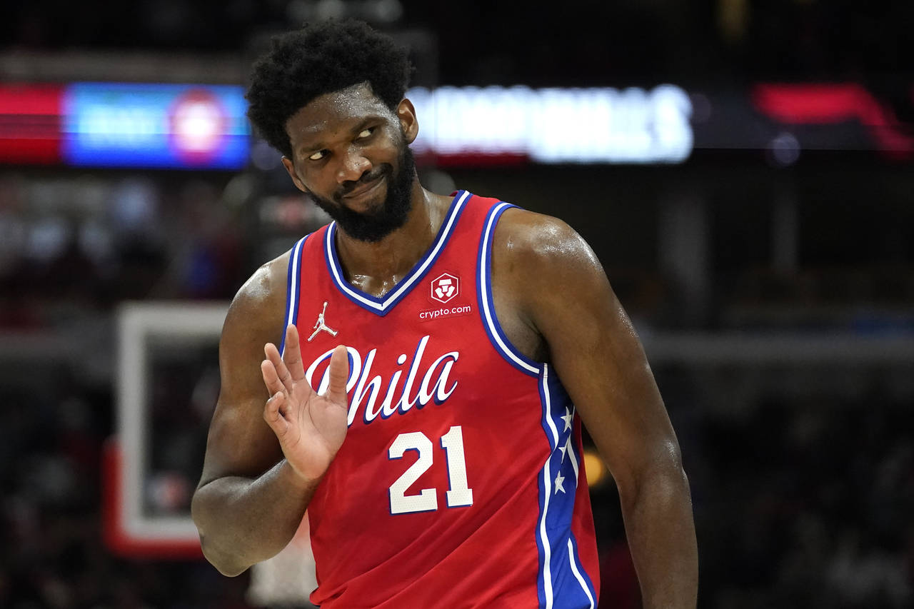 Philadelphia 76ers' Joel Embiid waves to Chicago Bulls fans after hitting a 3-point shot late in th...