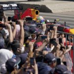 
              Fans cheer as Mexican Formula One Red Bull driver Sergio "Checo" Pérez drives by during an exhibition race along Paseo de la Reforma ahead of this weekend's Mexico Grand Prix in Mexico City, Wednesday, Nov. 3, 2021. (AP Photo/Fernando Llano)
            