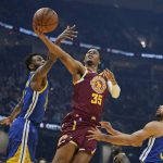 
              Cleveland Cavaliers' Isaac Okoro (35) drives to the basket against Golden State Warriors' Andrew Wiggins (22) and Stephen Curry (30) in the first half of an NBA basketball game, Thursday, Nov. 18, 2021, in Cleveland. (AP Photo/Tony Dejak)
            