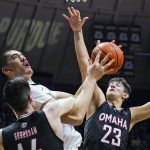 
              Purdue's Zach Edey (15) is fouled by Omaha's Dylan Brougham (14) and Frankie Fidler (23) as he shoots during the second half of an NCAA college basketball game in West Lafayette, Ind., Friday, Nov. 26, 2021. Purdue defeated Omaha 97-40. (AP Photo/Michael Conroy)
            