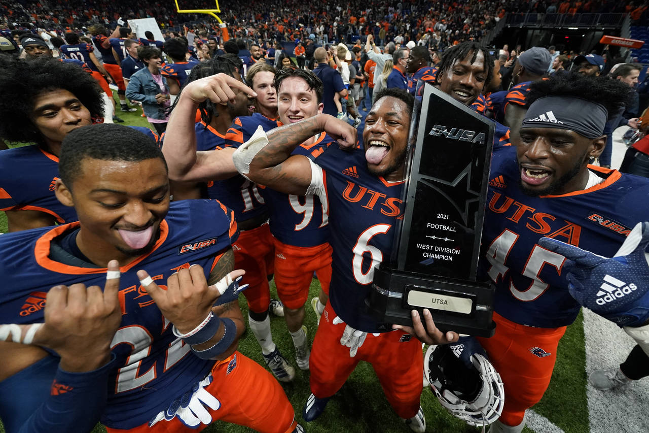 UTSA players celebrate with their conference trophy after their win over UAB in an NCAA college foo...