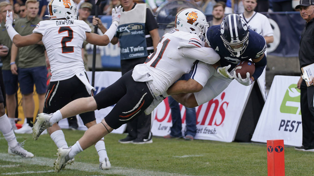 Idaho State linebacker Jared Gibson (51) knocks BYU wide receiver Neil Pau'u, right, out of bounds ...