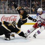 
              Boston Bruins goaltender Jeremy Swayman knocks the puck away from New York Rangers' Julien Gauthier during the first period of an NHL hockey game Friday, Nov. 26, 2021, in Boston. (AP Photo/Winslow Townson)
            