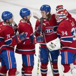 
              Montreal Canadiens goaltender Jake Allen (34) is congratulated by Sami Niku (15), Brett Kulak (77) and Jake Evans (71) after the team's win over the Detroit Red Wings in an NHL hockey game Tuesday, Nov. 2, 2021, in Montreal. (Ryan Remiorz/The Canadian Press via AP)
            