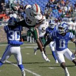 
              Miami wide receiver Jacolby George (15) gets upended as he tries to hurdle over Duke safeties Brandon Johnson (30) and Isaiah Fisher-Smith (11) on a punt return during the first half of an NCAA college football game Saturday, Nov. 27, 2021, in Durham, N.C. (AP Photo/Chris Seward)
            