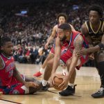 
              Detroit Pistons guard Cory Joseph (18) scoops up a loose ball in front of center Isaiah Stewart (28) and Toronto Raptors forward OG Anunoby (3) during the first half of an NBA basketball game, Saturday, Nov. 13, 2021, in Toronto. (Frank Gunn/The Canadian Press via AP)
            