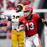 
              Georgia quarterback Stetson Bennett (13) looks for running room in the first half of an NCAA college football game against the Missouri Saturday, Nov. 6, 2021, in Athens, Ga.. (AP Photo/John Bazemore)
            