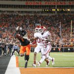 
              Oklahoma State wide receiver Tay Martin (1) catches a touchdown pass next to Oklahoma cornerback Woodi Washington (0) and defensive back Justin Broiles (25) during an NCAA college football game in Stillwater, Okla., Saturday, Nov. 27, 2021. (Ian Maule/Tulsa World via AP)
            