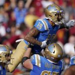 
              UCLA running back Kazmeir Allen, top, celebrates with offensive lineman Paul Grattan after scoring a touchdown during the first half of an NCAA college football game against Southern California Saturday, Nov. 20, 2021, in Los Angeles. (AP Photo/Mark J. Terrill)
            