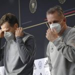 
              DFB director Oliver Bierhoff, left, and DFB doctor Tim Meyer leave a press conference wearing mouth-nose protection in Wolfsburg, Germany, prior the World Cup qualifying match against Liechtenstein, Tuesday, Nov. 9, 2021. There is said to be a positive Corona case in the national football team circle. National coach Hansi Flick cancelled the planned training in the morning at the stadium in Wolfsburg. Five players have to be quarantined in Wolfsburg. (Swen Pfoertner/dpa via AP)
            