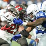 
              Tampa Bay Buccaneers' Ronald Jones (27) runs against Indianapolis Colts' Bobby Okereke (58) during the first half of an NFL football game, Sunday, Nov. 28, 2021, in Indianapolis. (AP Photo/Michael Conroy)
            
