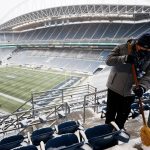 SEATTLE, WASHINGTON - DECEMBER 26: A field employee sweeps snow off the aisles and seats at Lumen Field before the game between the Seattle Seahawks and Chicago Bears on December 26, 2021 in Seattle, Washington. (Photo by Steph Chambers/Getty Images)