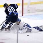 
              Winnipeg Jets' Pierre-Luc Dubois (80) collides with Toronto Maple Leafs goaltender Joseph Woll (60) as he leaves the crease after the puck during the third period of NHL hockey game action in Winnipeg, Manitoba, Sunday, Dec. 5, 2021. (Fred Greenslade/The Canadian Press via AP)
            