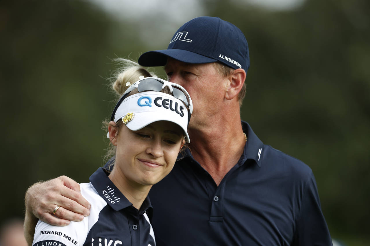 Petr Korda, right, kisses his daughter Nelly Korda while walking off the first tee during the secon...