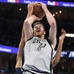 
              San Antonio Spurs center Jakob Poeltl (25) is fouled from behind by Memphis Grizzlies forward Kyle Anderson during the first half of an NBA basketball game Friday, Dec. 31, 2021, in Memphis, Tenn. (AP Photo/Nikki Boertman)
            