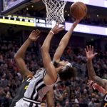 
              San Antonio Spurs guard Derrick White, left, attempts a layup as San Antonio Spurs center Jakob Poeltl, middle, and Utah Jazz guard Jakob Poeltl, right, look on during the first half of an NBA basketball game on Friday, Dec. 17 2021, in Salt Lake City. (AP Photo/Kim Raff)
            