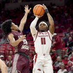 
              Arkansas guard Chris Lykes (11). Shoots over Arkansas-Little Rock guard D.J. Smith (13) during the first half of an NCAA college basketball game Saturday, Dec. 4, 2021, in Fayetteville, Ark. (AP Photo/Michael Woods)
            