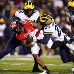 
              Maryland running back Tayon Fleet-Davis (8) is tackled by Michigan defensive lineman Donovan Jeter (95) and linebacker Michael Barrett (23) during the first half of an NCAA college football game, Saturday, Nov. 20, 2021, in College Park, Md. Michigan won 59-18. (AP Photo/Julio Cortez)
            
