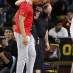 
              Utah center Branden Carlson (35) is helped off the court during the first half of the team's NCAA college basketball game against Southern California in Los Angeles, Wednesday, Dec. 1, 2021. (AP Photo/Alex Gallardo)
            
