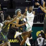 
              Oregon guard De'Vion Harmon (5) passes against Baylor during the first half of an NCAA college basketball game in Eugene, Ore., Saturday, Dec. 18, 2021. (AP Photo/Thomas Boyd)
            