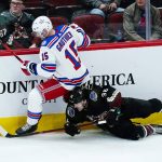 
              New York Rangers right wing Julien Gauthier (15) sends Arizona Coyotes right wing Christian Fischer (36) to the ice during the first period of an NHL hockey game Wednesday, Dec. 15, 2021, in Glendale, Ariz. (AP Photo/Ross D. Franklin)
            