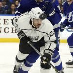 
              Los Angeles Kings center Andreas Athanasiou (22) tips the puck after getting checked by Tampa Bay Lightning defenseman Victor Hedman (77) during the first period of an NHL hockey game Tuesday, Dec. 14, 2021, in Tampa, Fla. (AP Photo/Chris O'Meara)
            