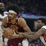 
              Cleveland Cavaliers' Jarrett Allen, center, tries to get past Miami Heat's Kyle Lowry, right, and Dewayne Dedmon in the first half of an NBA basketball game, Monday, Dec. 13, 2021, in Cleveland. Lowry was called for a foul. (AP Photo/Tony Dejak)
            